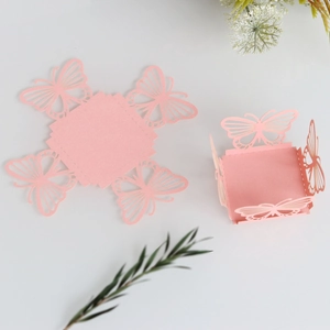 Detail of pink laser-cut candy box with hollow butterfly design for wedding parties