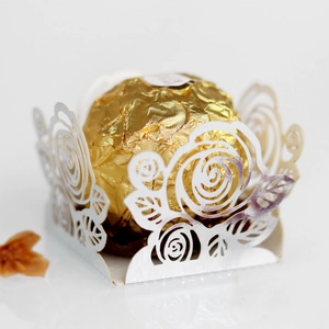 Détail de l'emballage en papier blanc découpé au laser pour chocolat avec truffe dorée