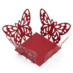 Close-up of laser-cut red butterfly paper lace wrapper for cupcake and candy box