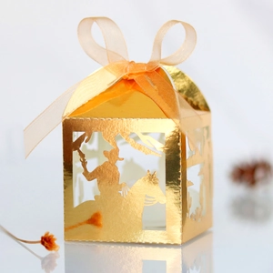 Detail of laser-cut gold candy box with horse silhouette and satin ribbon bow