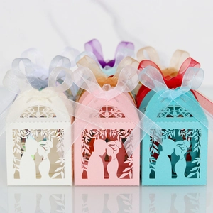 Macro detail of laser-cut wedding favor boxes with romantic silhouette and organza ribbon