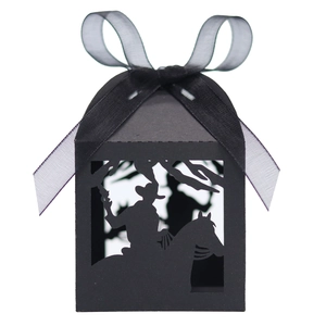 Detail of laser-cut black cowboy knight candy box with elegant organza ribbon bow
