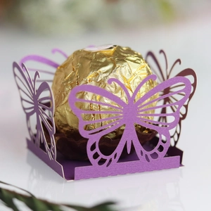 Close-up of laser-cut purple butterfly hollow design holding golden chocolate ball