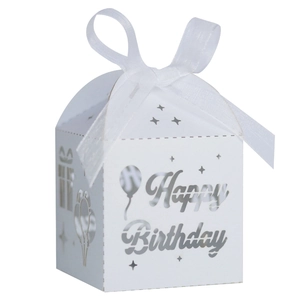 Close-up of white laser-cut Happy Birthday candy box with balloon pattern and ribbon