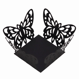 Detail of laser-cut black butterfly cupcake wrapper with hollow design for wedding parties