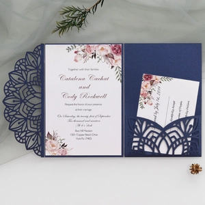 Detail of laser-cut mandala navy blue wedding invitation with floral insert and RSVP card