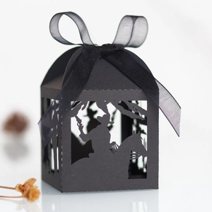 Detail showing a black laser-cut candy box with a horse silhouette and black ribbon