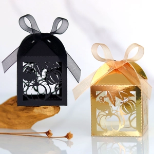 Detail of laser-cut pumpkin and maple leaf patterns on gold and black gift boxes