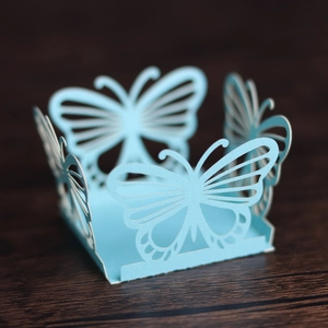 Close-up of light blue laser-cut butterfly candy box with intricate hollow patterns