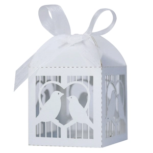 Détail de la boîte à bonbons blanche découpée au laser avec ruban et motifs d'oiseaux