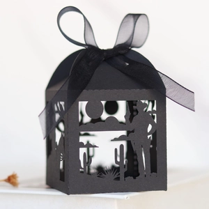 Laser cut black paper gift box featuring desert cowboy scene and elegant ribbon bow