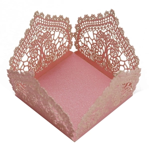 Macro detail of laser-cut lace pattern on pink pearlescent paper wedding candy box