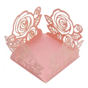 Vue détaillée d'une boîte cadeau rose en papier perlé avec motifs de roses découpés