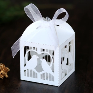 Détail de la boîte à bonbons blanche découpée au laser avec motif de cœur et nœud en satin