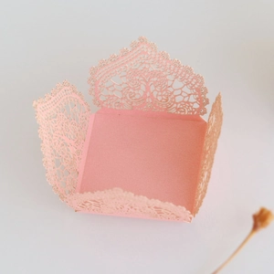 Detailed macro view of laser-cut lace pattern on pink wedding favor candy box