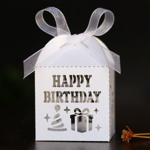 Close-up of white laser-cut Happy Birthday gift box with elegant organza ribbon bow