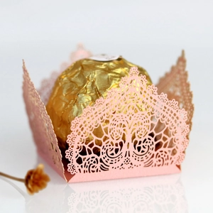 Close-up of laser-cut candy box with intricate lace pattern holding a chocolate