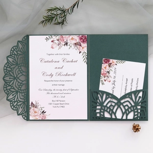 Close-up of laser-cut emerald green wedding invitation with elegant floral insert card