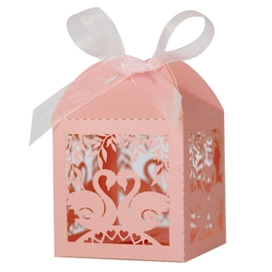 Pink laser-cut wedding favor box with swan heart design and white satin ribbon