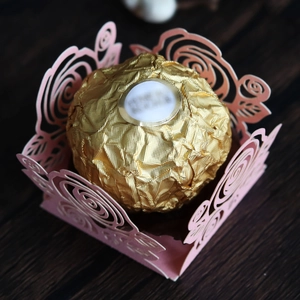 Détail macro d'une boîte à bonbons rose découpée au laser sur un fond en bois