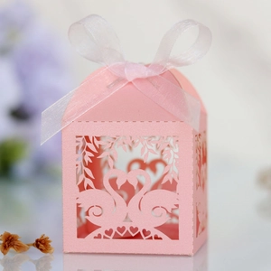Detail of pink laser-cut swan heart wedding favor box with white translucent ribbon bow