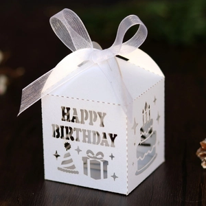 Detail of laser-cut Happy Birthday white favor box with elegant silk ribbon bow