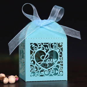 Close-up of laser-cut light blue candy box with Love hollow design and organza ribbon