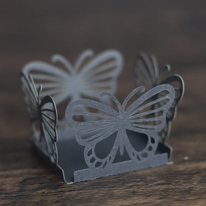 Detail of laser-cut butterfly cupcake wrappers in grey for wedding party dessert decor
