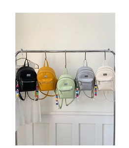 Mini sacs à dos en cinq couleurs avec logo métallique et pompons de perles arc-en-ciel
