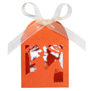 Detail showing orange laser-cut cowboy silhouette gift box with white ribbon bow