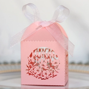 Gros plan sur la boîte à bonbons rose découpée au laser avec motif floral et ruban