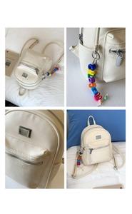 Détail du sac à dos beige en cuir grainé avec logo argenté et breloque arc-en-ciel