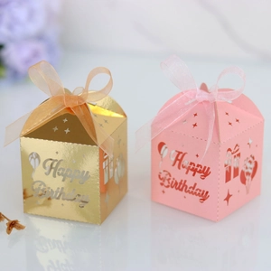 Detail of laser-cut Happy Birthday candy boxes with ribbon bows in gold and pink