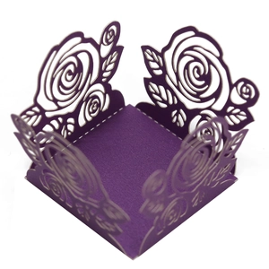 Détail des motifs de roses découpés au laser sur un coffret cadeau en papier violet foncé