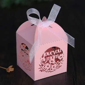 Détail de la boîte cadeau rose découpée au laser avec texte Love You Mom et ruban blanc
