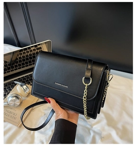 Detail of black rectangular flap bag with gold chain and Fashion & Bags text on leather