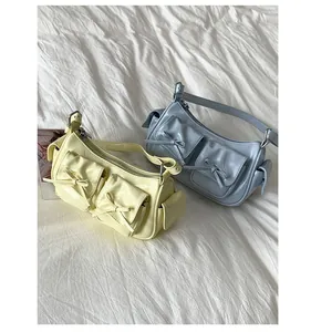 Détail de sacs à bandoulière en cuir verni brillant avec poches à nœuds jaune et bleu