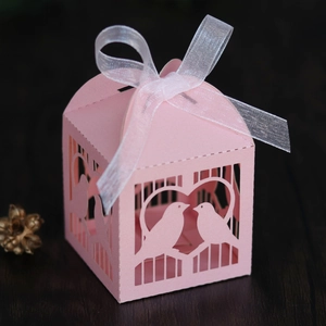 Détail de la boîte à dragées rose découpée au laser avec motif oiseaux et ruban en organza