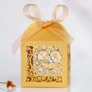 Detailed laser-cut gold wedding favor box with Love script and matching organza ribbon