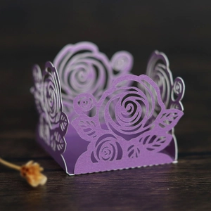 Gros plan de caissette à cupcake violette avec motifs de roses découpés au laser