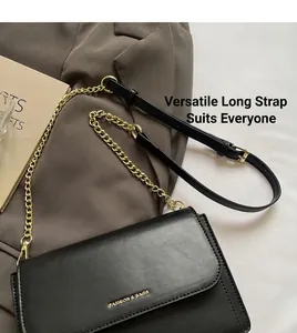 Close-up of black leather crossbody bag featuring gold chain strap and stylish logo