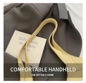 Close-up of beige tote bag shoulder strap with premium lychee grain texture and fine stitching