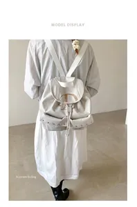 Detail of off-white nylon backpack featuring metal rivet accents and bold letter D print