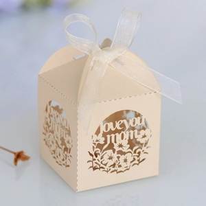 Détail du motif floral 'love you mom' découpé au laser sur boîte cadeau beige avec ruban