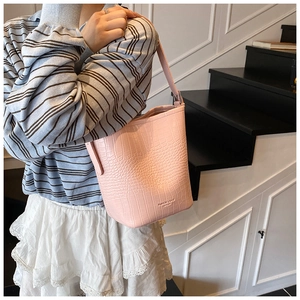 Detailed macro view of pink crocodile texture bucket bag with embossed logo