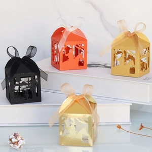Detail of laser-cut cowboy theme candy boxes with silk ribbons in gold and black