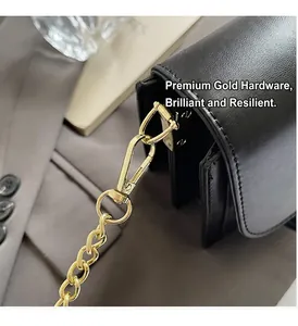 Detail view of black vintage crossbody bag showing golden metal hooks and layered side design