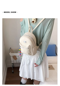 Gros plan détaillé d'un mini sac à dos en cuir crème avec texture grainée sur un mannequin