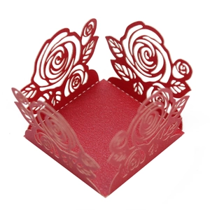 Vue macro d'un emballage en papier rouge découpé au laser avec roses pour dragées de mariage