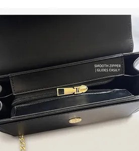 Detail of internal zipper pocket and golden magnetic snap on a black leather handbag
